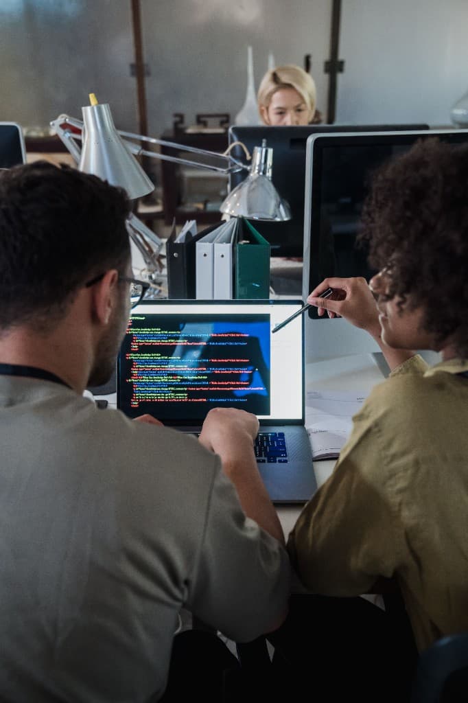 Two people reviewing the build together on a laptop.